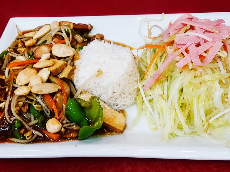 Saltejat de la casa al wok amb ametlles, arròs i amanida
